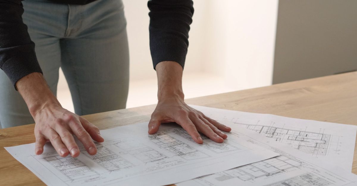 Inside Properties - Mains posées sur des plans d'architecture