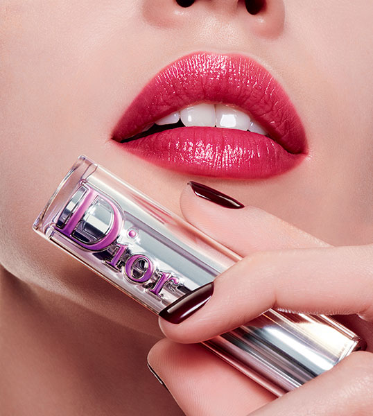 Une bouche maquillée et le packaging du rouge à lèvres Dior Addict Stellar Shine.