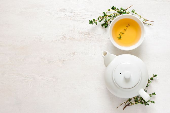 Théière et tasse de thé aux herbes.