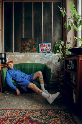 Eddy de Pretto photographié allongé sur un canapé par Justin Paquay.
