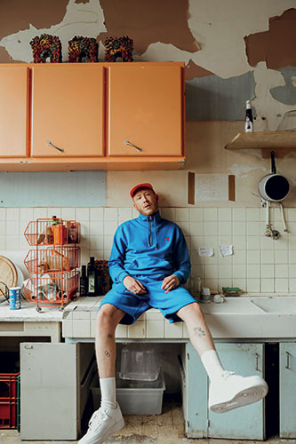Eddy de Preto assis sur le plan de travail d'une cuisine par Justin Paquay.