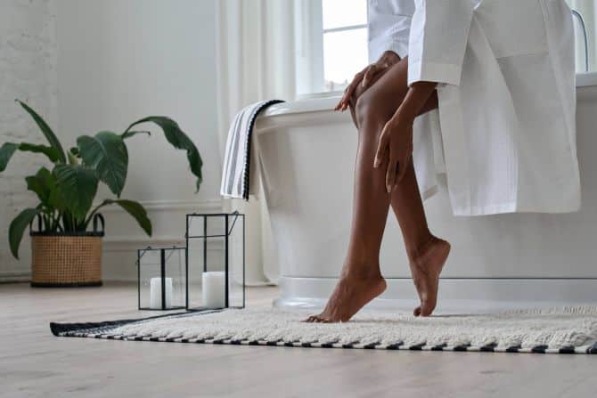 femme dans la salle de bain avec sa main posée sur sa jambe