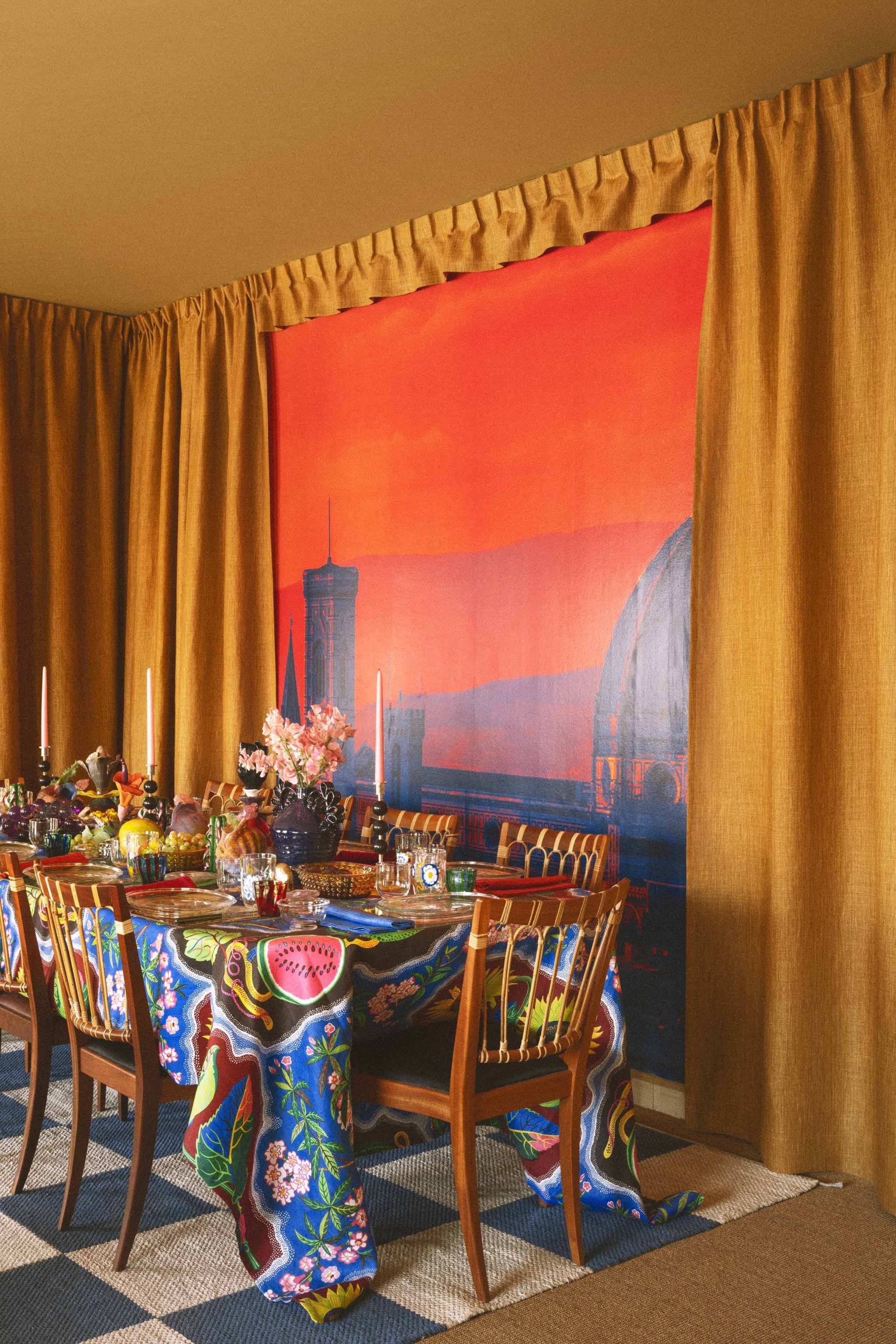 colorful dining table with floral tablecloth and eclectic decor against a vibrant backdrop