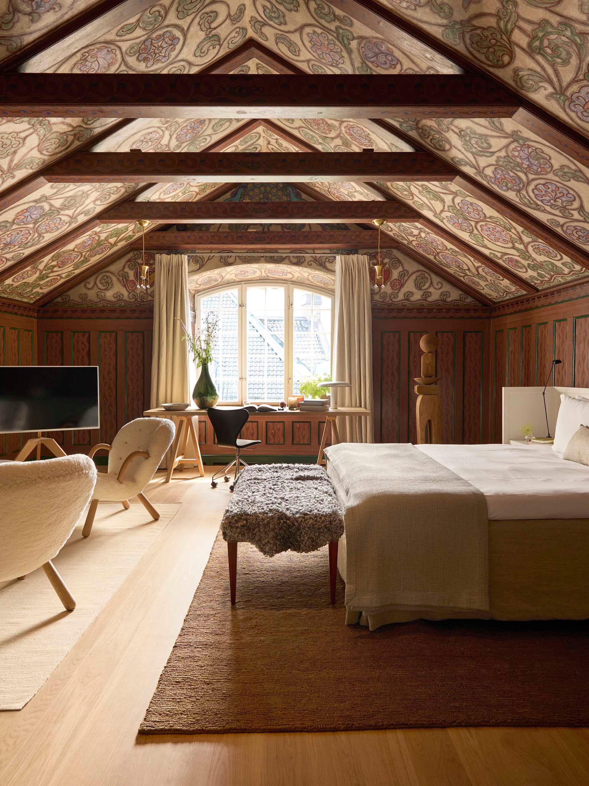 Attic Suite5 copy.jpg cozy attic bedroom with decorative wooden ceiling and vintage furnishings.